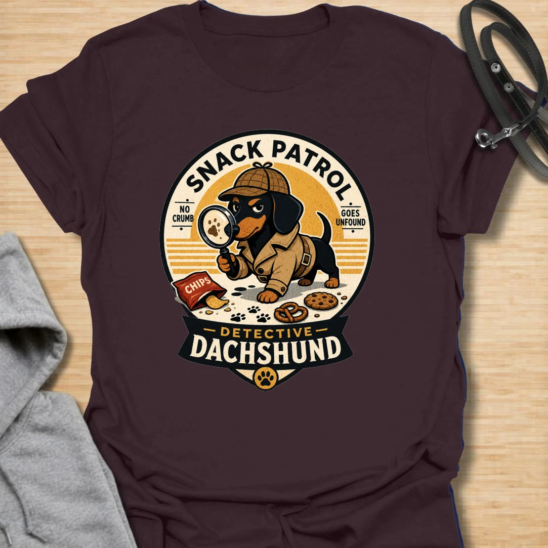 Snack Patrol Detective Dachshund t-shirt for the doxie who is always first on the scene when food appears. This funny badge-style design features a dachshund detective theme with snack details and retro lettering. It is perfect for dachshund owners whose dog monitors every bite, crumb, and kitchen sound. A great gift for wiener dog lovers, sausage dog fans, and food-motivated dog households.