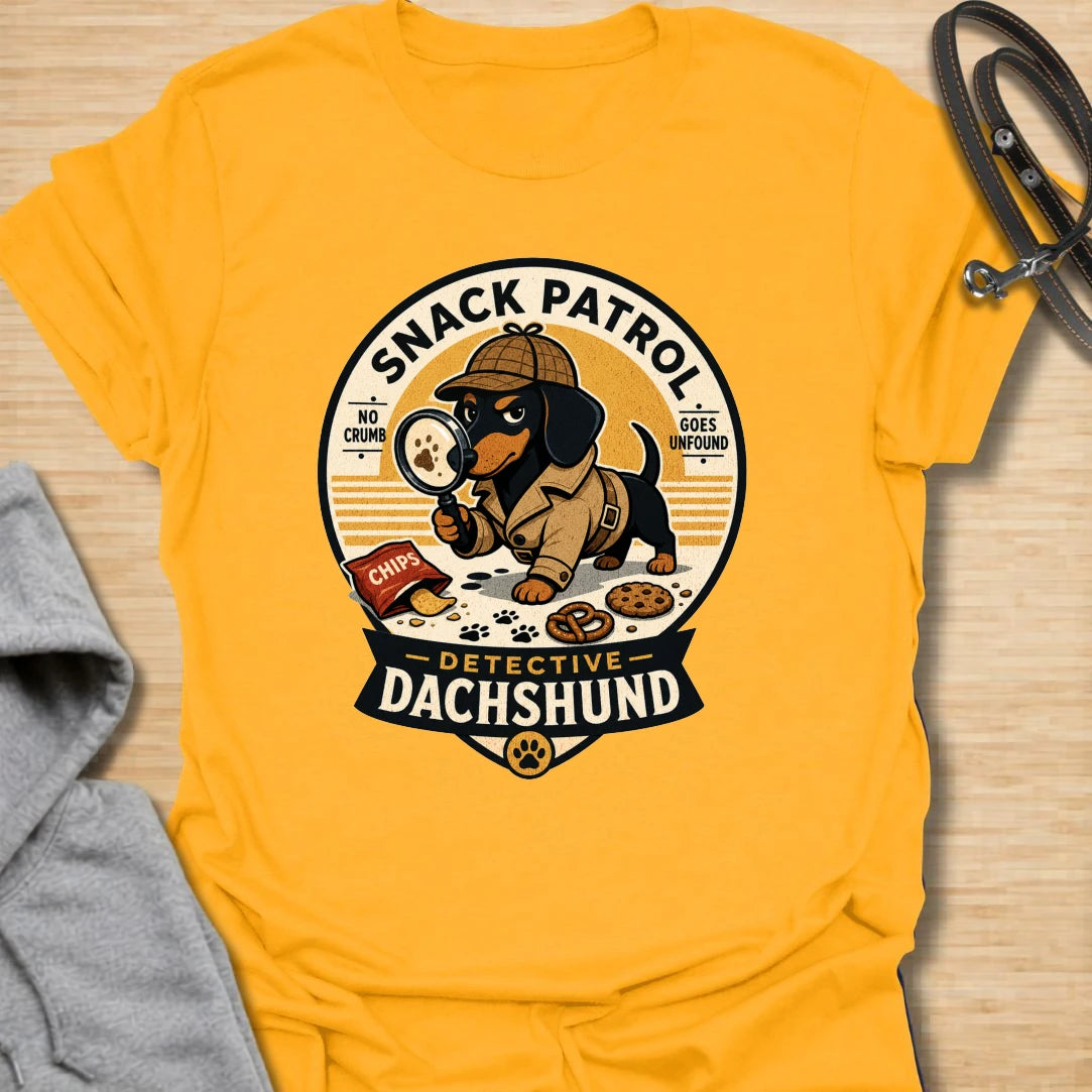 Snack Patrol Detective Dachshund t-shirt for the doxie who is always first on the scene when food appears. This funny badge-style design features a dachshund detective theme with snack details and retro lettering. It is perfect for dachshund owners whose dog monitors every bite, crumb, and kitchen sound. A great gift for wiener dog lovers, sausage dog fans, and food-motivated dog households.