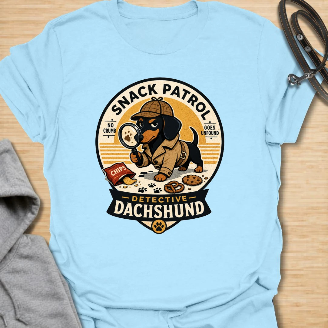 Snack Patrol Detective Dachshund t-shirt for the doxie who is always first on the scene when food appears. This funny badge-style design features a dachshund detective theme with snack details and retro lettering. It is perfect for dachshund owners whose dog monitors every bite, crumb, and kitchen sound. A great gift for wiener dog lovers, sausage dog fans, and food-motivated dog households.