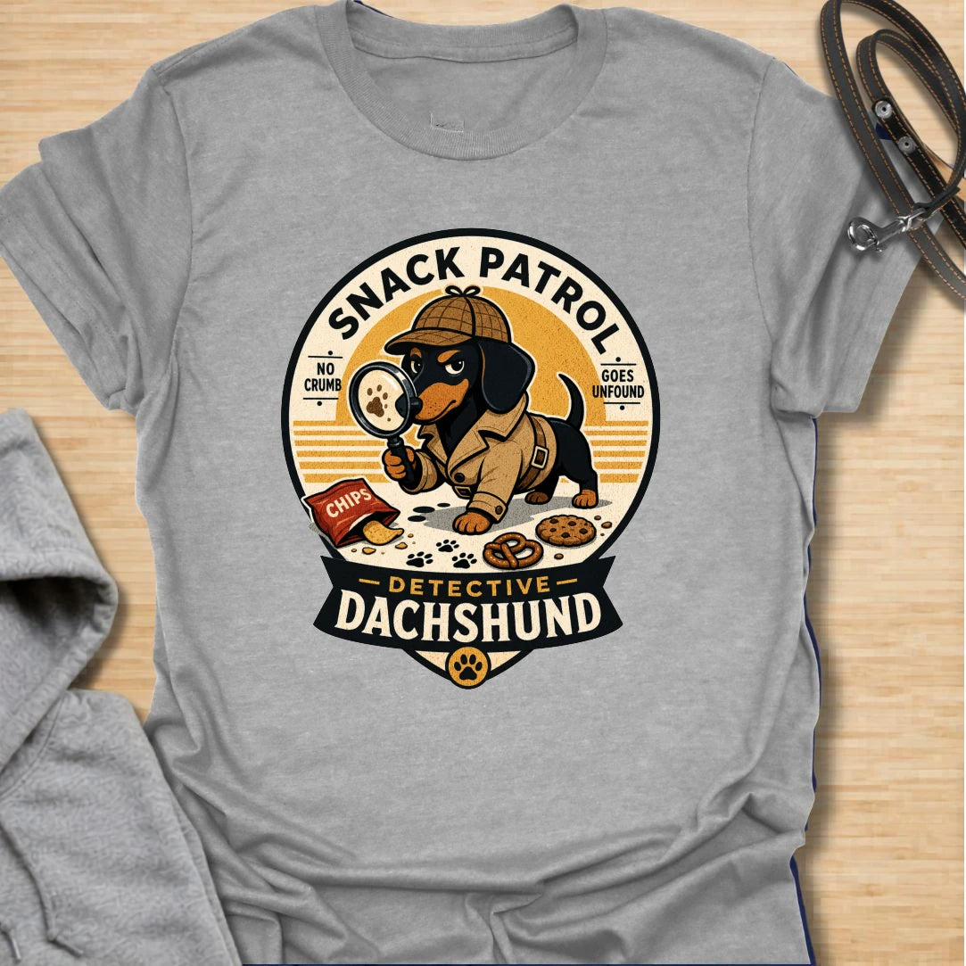Snack Patrol Detective Dachshund t-shirt for the doxie who is always first on the scene when food appears. This funny badge-style design features a dachshund detective theme with snack details and retro lettering. It is perfect for dachshund owners whose dog monitors every bite, crumb, and kitchen sound. A great gift for wiener dog lovers, sausage dog fans, and food-motivated dog households.