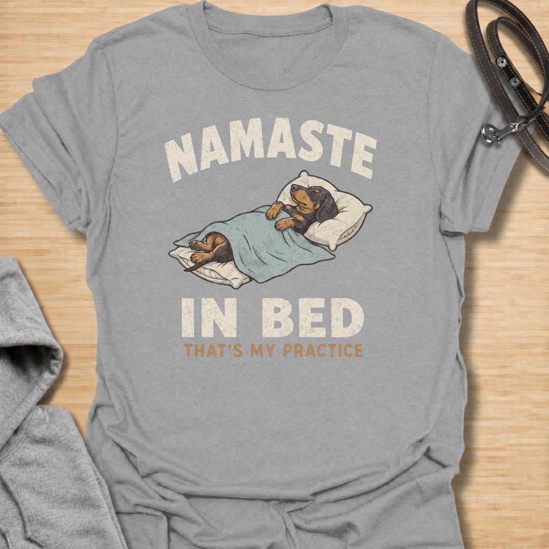 Celebrate the dachshund approach to yoga with this funny “Namaste in Bed” T-shirt. Featuring a cozy sausage dog tucked beneath the blankets with the phrase “That’s My Practice,” it is perfect for dachshund moms, dog dads, homebodies, and yoga lovers. A playful gift for anyone who prefers relaxation, naps, and staying comfortably in bed.