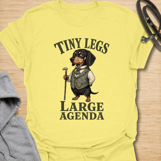 This Tiny Legs Large Agenda t-shirt is made for dachshund lovers who know their little long dog has plans, opinions, and absolutely no time to waste. Featuring a dressed-up dachshund with a cane and bold vintage-style lettering, this design has a funny, dramatic dog-parent feel. Perfect for dachshund moms, dachshund dads, wiener dog fans, rescue dog lovers, and anyone whose tiny-legged dog has big plans.