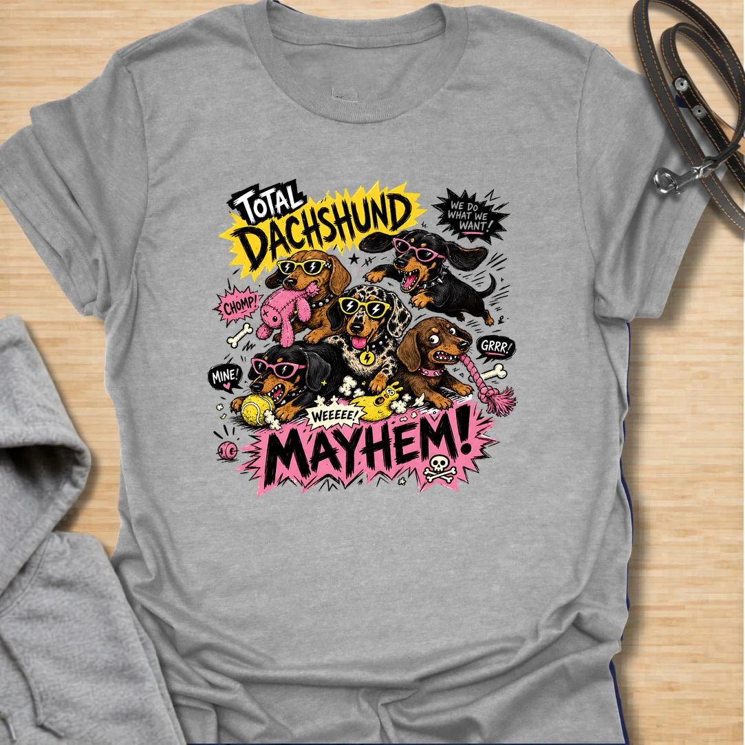 Dachshund Mayhem t-shirt for doxie lovers who live with tiny chaos, loud opinions, and nonstop sausage dog energy. This bold comic-style design features a wild pack of dachshunds causing total mayhem with toys, sunglasses, and attitude. Perfect for dachshund moms, multi-dog homes, and anyone who loves loud, funny dog designs.