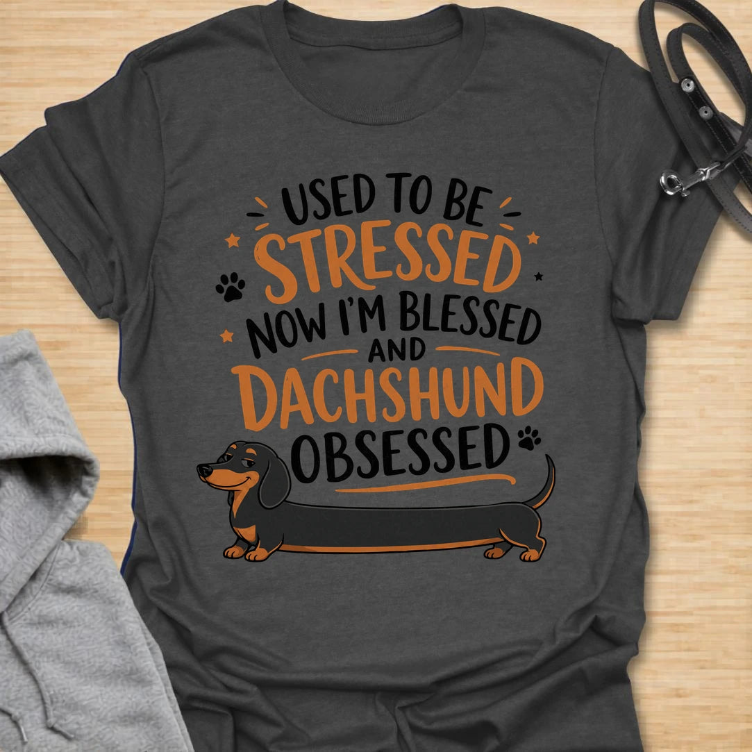 This Used To Be Stressed Now I’m Blessed And Dachshund Obsessed t-shirt is made for dachshund lovers who know life got a whole lot better with a sausage dog in it. Featuring playful stacked typography, a long dachshund illustration, and a fun feel-good message, this design has a cheerful and relatable dog-lover vibe. Perfect for dachshund moms, dachshund dads, wiener dog fans, doxie owners, and anyone who proudly admits they are completely dachshund obsessed.