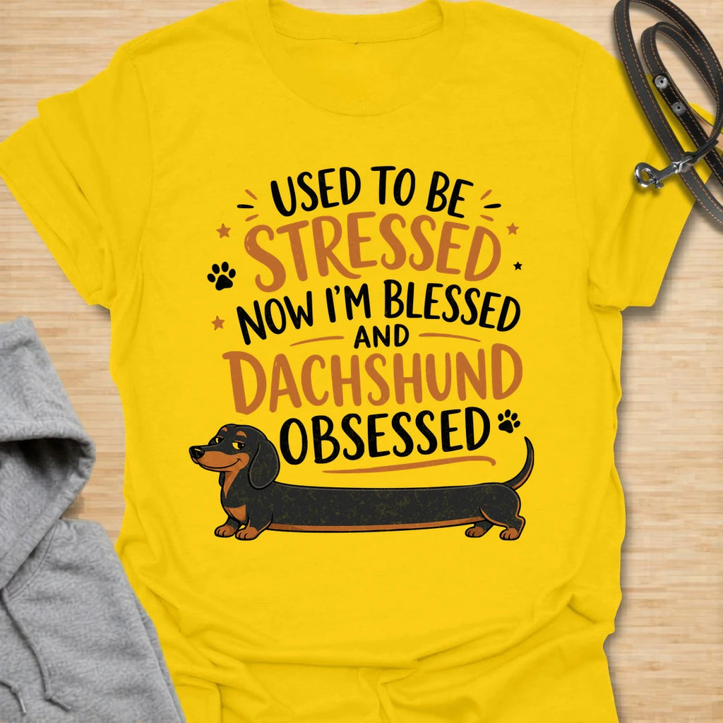 This Used To Be Stressed Now I’m Blessed And Dachshund Obsessed t-shirt is made for dachshund lovers who know life got a whole lot better with a sausage dog in it. Featuring playful stacked typography, a long dachshund illustration, and a fun feel-good message, this design has a cheerful and relatable dog-lover vibe. Perfect for dachshund moms, dachshund dads, wiener dog fans, doxie owners, and anyone who proudly admits they are completely dachshund obsessed.