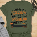 This Used To Be Stressed Now I’m Blessed And Dachshund Obsessed t-shirt is made for dachshund lovers who know life got a whole lot better with a sausage dog in it. Featuring playful stacked typography, a long dachshund illustration, and a fun feel-good message, this design has a cheerful and relatable dog-lover vibe. Perfect for dachshund moms, dachshund dads, wiener dog fans, doxie owners, and anyone who proudly admits they are completely dachshund obsessed.