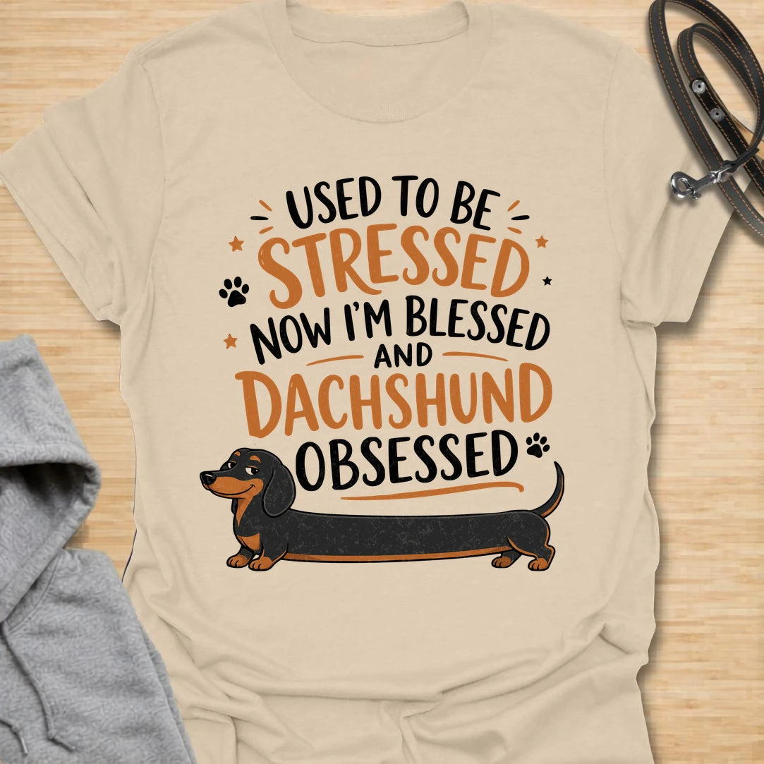 This Used To Be Stressed Now I’m Blessed And Dachshund Obsessed t-shirt is made for dachshund lovers who know life got a whole lot better with a sausage dog in it. Featuring playful stacked typography, a long dachshund illustration, and a fun feel-good message, this design has a cheerful and relatable dog-lover vibe. Perfect for dachshund moms, dachshund dads, wiener dog fans, doxie owners, and anyone who proudly admits they are completely dachshund obsessed.
