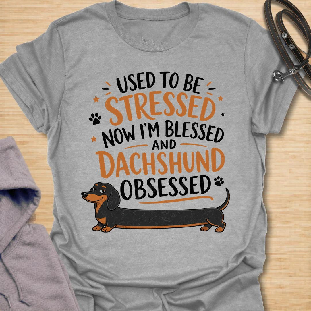 This Used To Be Stressed Now I’m Blessed And Dachshund Obsessed t-shirt is made for dachshund lovers who know life got a whole lot better with a sausage dog in it. Featuring playful stacked typography, a long dachshund illustration, and a fun feel-good message, this design has a cheerful and relatable dog-lover vibe. Perfect for dachshund moms, dachshund dads, wiener dog fans, doxie owners, and anyone who proudly admits they are completely dachshund obsessed.