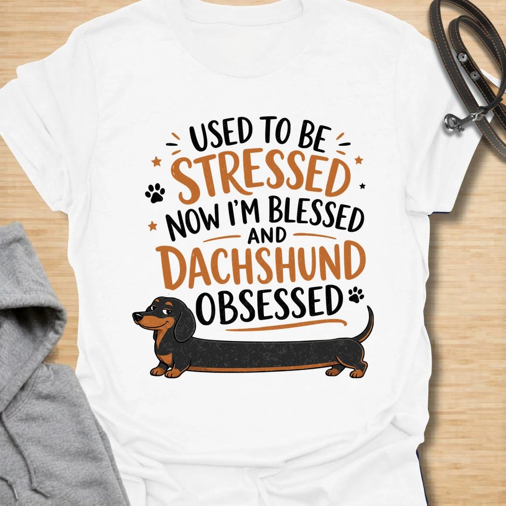 This Used To Be Stressed Now I’m Blessed And Dachshund Obsessed t-shirt is made for dachshund lovers who know life got a whole lot better with a sausage dog in it. Featuring playful stacked typography, a long dachshund illustration, and a fun feel-good message, this design has a cheerful and relatable dog-lover vibe. Perfect for dachshund moms, dachshund dads, wiener dog fans, doxie owners, and anyone who proudly admits they are completely dachshund obsessed.
