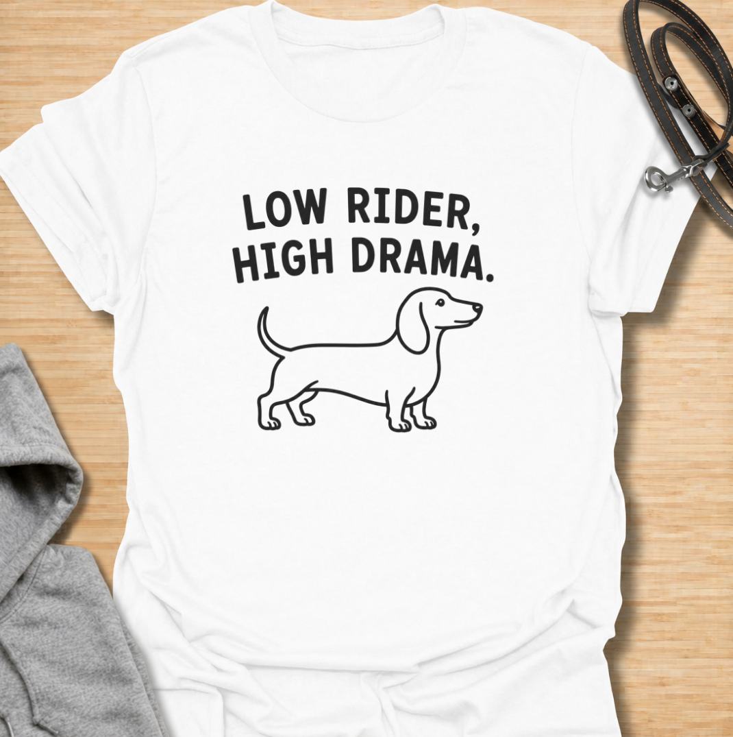 Low to the ground and never short on drama. This funny dachshund T-shirt features a clean minimalist sausage dog illustration with the phrase “Low Rider, High Drama.” A simple, wearable gift for dachshund owners, doxie lovers, dog moms, and anyone familiar with the breed’s larger-than-life personality.
