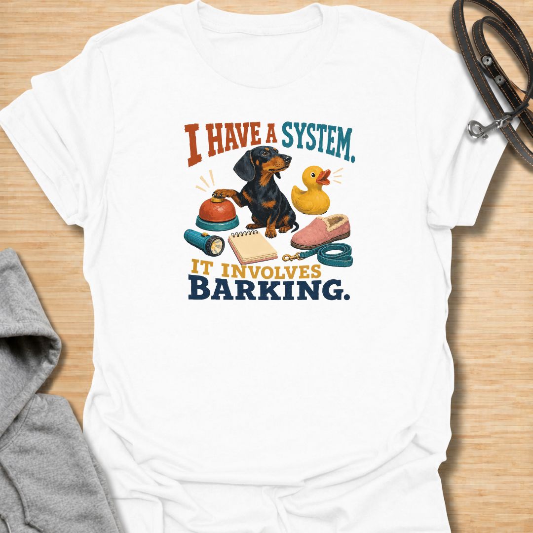 Every dachshund has a system—and it usually involves barking. This funny dachshund T-shirt features a determined sausage dog surrounded by its essential barking equipment, making it perfect for doxie owners who know the routine. A playful everyday tee and a fun gift for dachshund moms, dads, and devoted dog lovers.