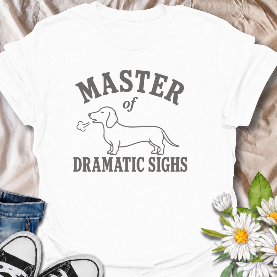 For the dachshund who turns every minor inconvenience into a full performance. This funny dachshund T-shirt features a simple sausage dog illustration with the phrase “Master of Dramatic Sighs.” A playful, easy-to-wear gift for dachshund owners, dog moms, dog dads, and anyone familiar with classic doxie drama.
