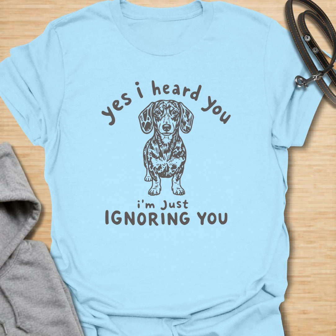Ignoring You t-shirt for dachshund owners who know their dog hears everything but chooses selective listening. This funny design features a serious doxie with the phrase “Yes I Heard You I’m Just Ignoring You.” Perfect for sausage dog fans, doxie moms, and anyone living with a stubborn little dog.
