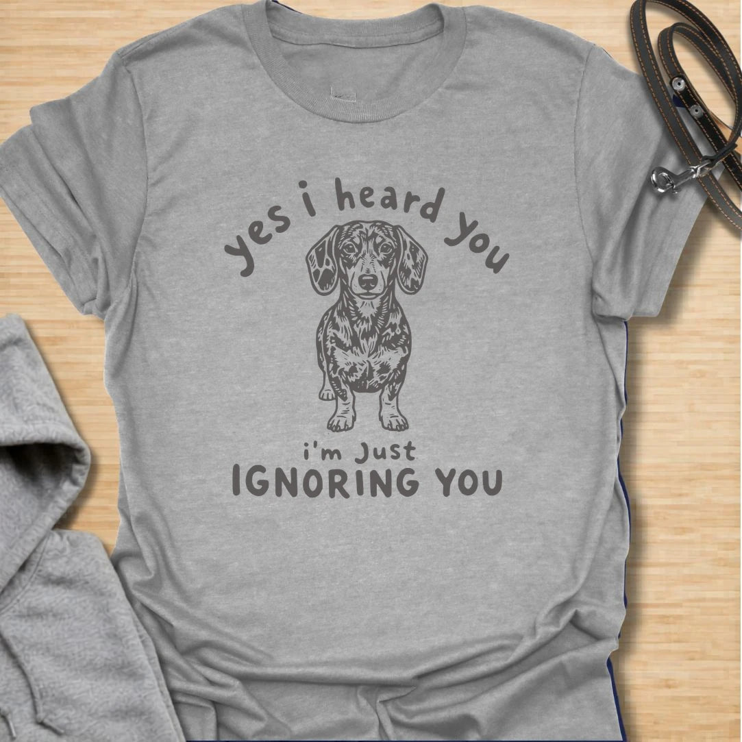 Ignoring You t-shirt for dachshund owners who know their dog hears everything but chooses selective listening. This funny design features a serious doxie with the phrase “Yes I Heard You I’m Just Ignoring You.” Perfect for sausage dog fans, doxie moms, and anyone living with a stubborn little dog.