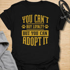 This You Can’t Buy Loyalty But You Can Adopt It t-shirt is made for rescue dog lovers who believe the best kind of love comes from giving a dog a second chance. Featuring bold distressed typography with paw print details, this design has a simple, meaningful rescue-dog message that is easy to wear every day. Perfect for rescue dog moms, rescue dog dads, shelter dog adopters, foster families, animal lovers, and anyone who proudly supports adoption. Black