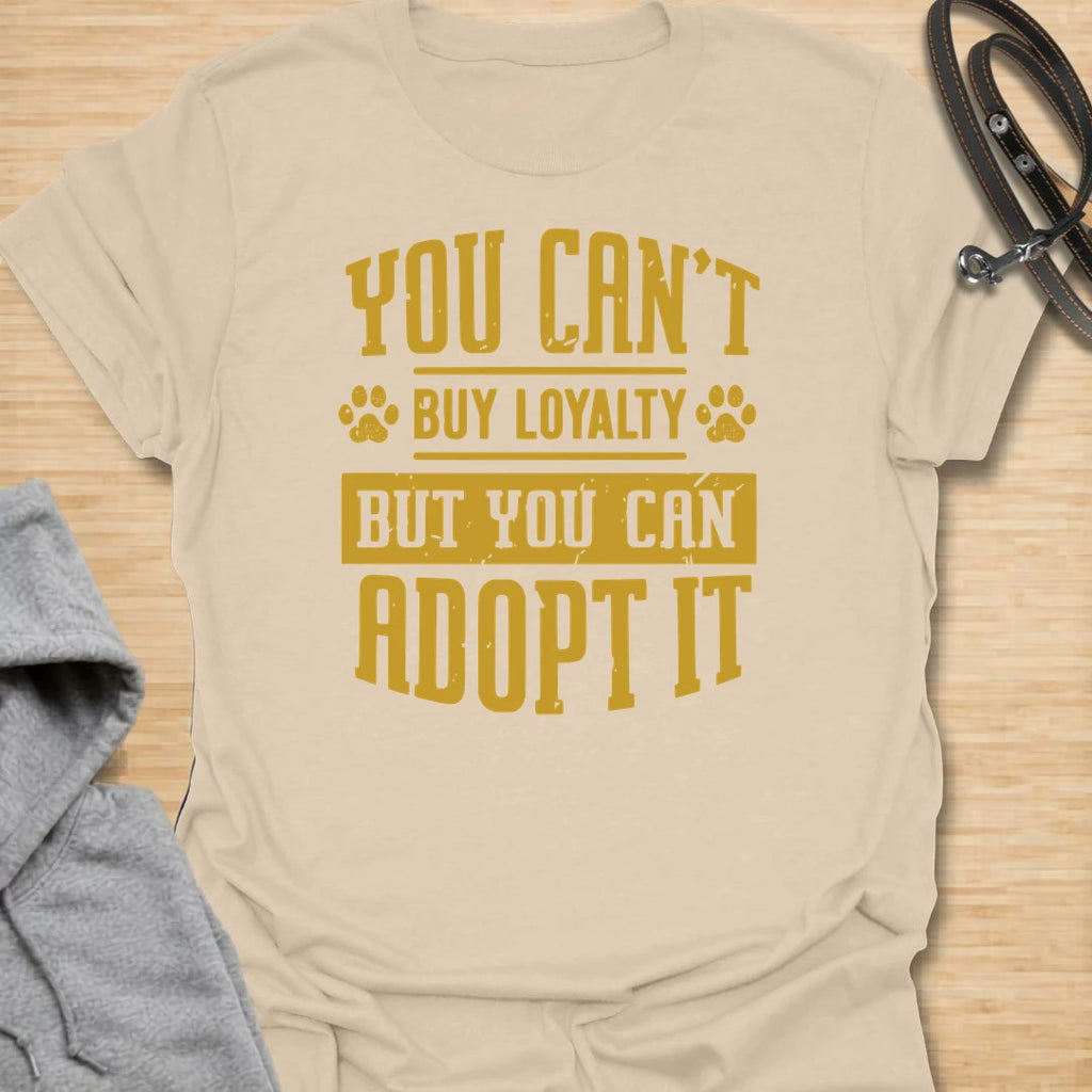 This You Can’t Buy Loyalty But You Can Adopt It t-shirt is made for rescue dog lovers who believe the best kind of love comes from giving a dog a second chance. Featuring bold distressed typography with paw print details, this design has a simple, meaningful rescue-dog message that is easy to wear every day. Perfect for rescue dog moms, rescue dog dads, shelter dog adopters, foster families, animal lovers, and anyone who proudly supports adoption. Sand